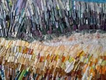 A mosaic made of glass and quartz in bands of dark and golden colours.